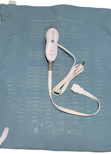 Electric heating pad with control switch and power cord on blue fabric