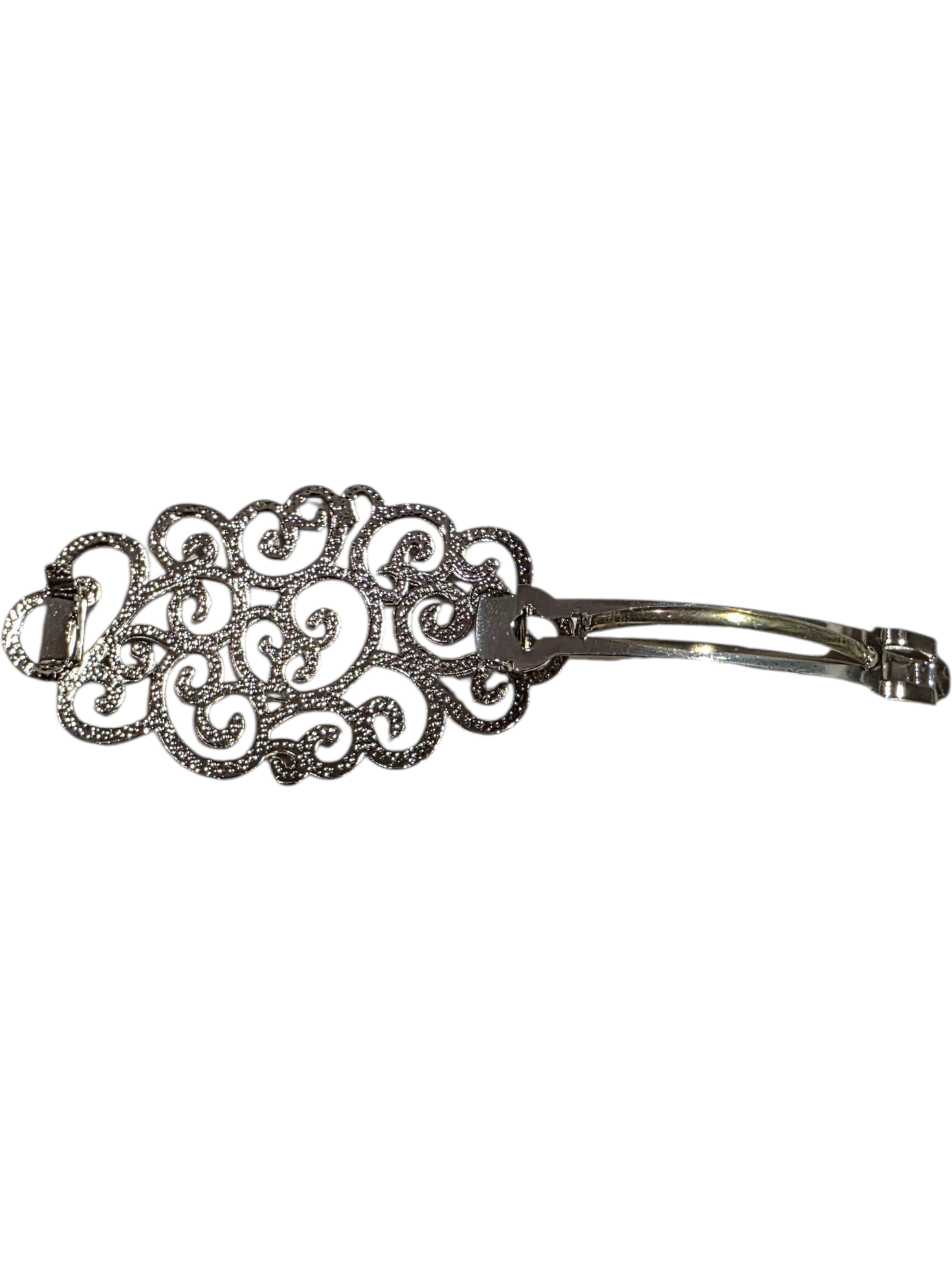 Intricate silver hair brooch measuring 8cm by 4cm with decorative filigree design