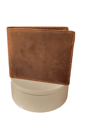 Brown leather wallet standing on a cylindrical base.