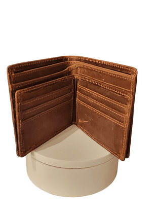 Open brown leather wallet standing on a round white pedestal