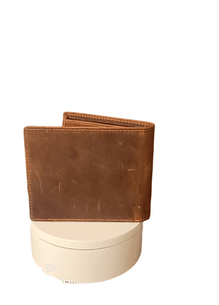 Brown leather wallet on a round white stand.